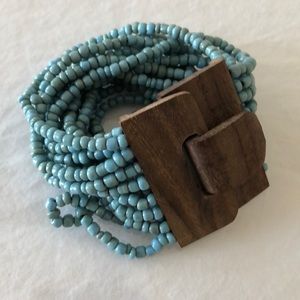 Multi-strand turquoise bracelet with wooden clasp.